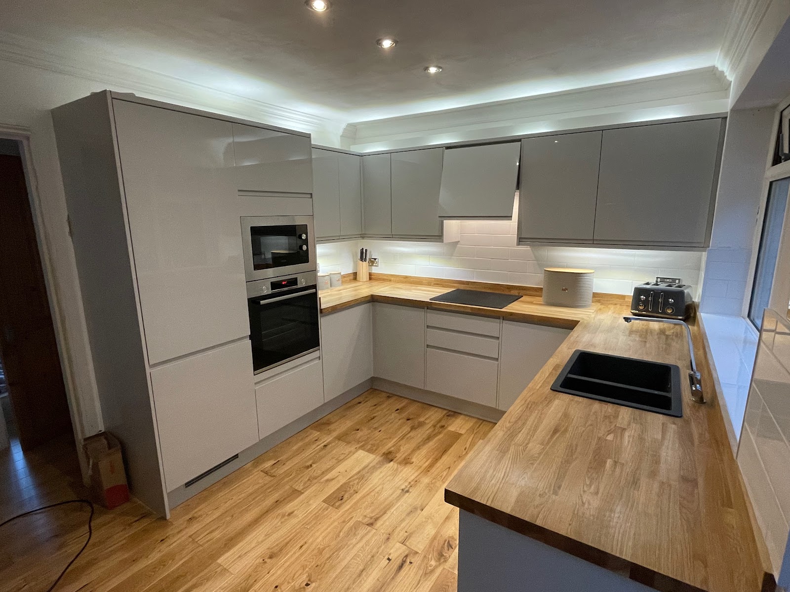 Green Block kitchen fit with oak worktops and metro tiles